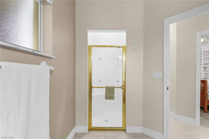 Full bath featuring a stall shower and light tile patterned floors