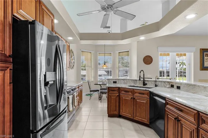 Kitchen with stainless steel appliances, healthy amount of natural light, light stone counters, and recessed lighting