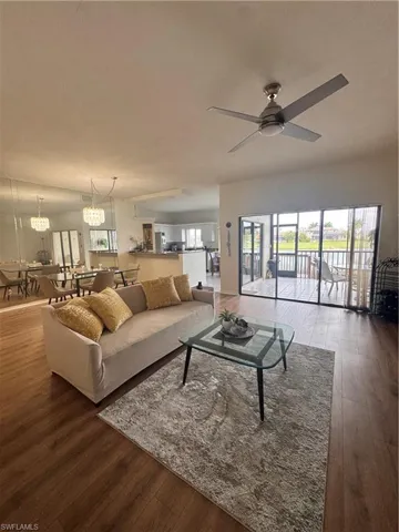 Living area featuring hardwood flooring, a ceiling fan, and large sliding glass doors leading to an outdoor space