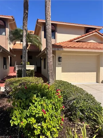 Exterior featuring a neutral stucco finish, orange tile roofing, and an attached garage with a number '302' address plaque