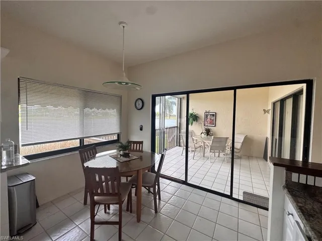 Bright dining area with tile flooring and a vaulted ceiling