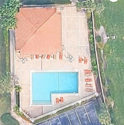 Community pool area featuring a rectangular pool with integrated steps, surrounded by a concrete patio