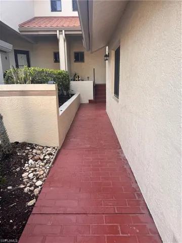 The property features a red brick-patterned walkway, leading to an entrance with a tiled roof