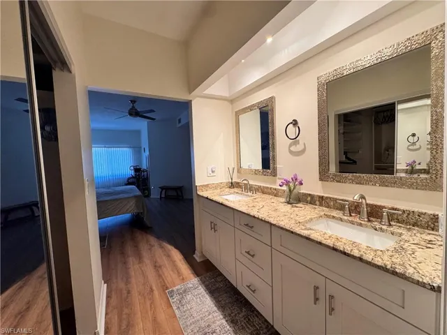 Dual vanity with a stone countertop, under-mount sinks, and framed mirrors