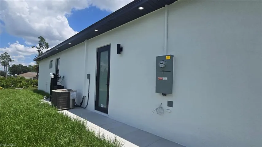 View of side of property with stucco siding and a central AC unit