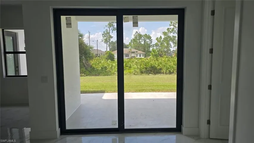 Doorway to outside with marble finish flooring and baseboards