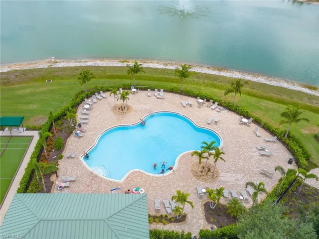 View of swimming pool featuring a patio, a water view, and a yard