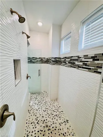 Bathroom featuring a stall shower and tile walls