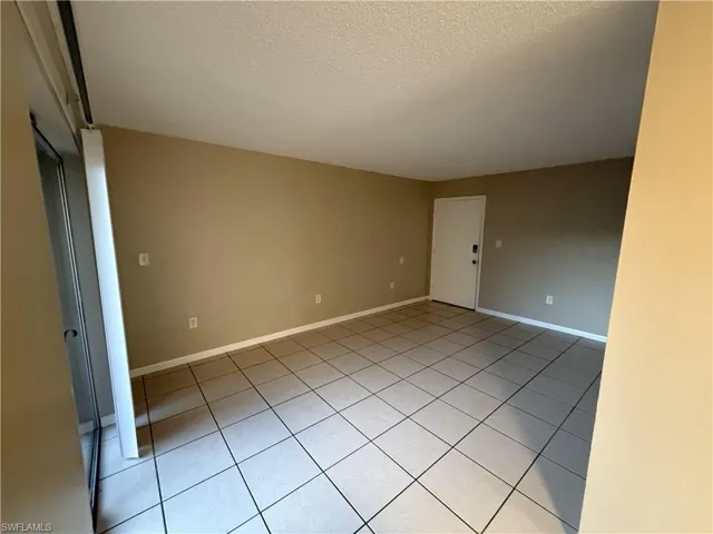 Unfurnished room with light tile patterned floors and a textured ceiling