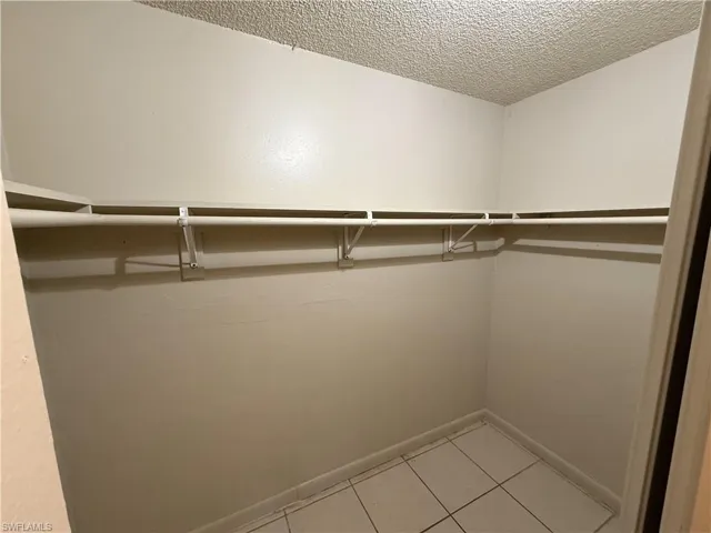 Walk in closet with light tile patterned floors