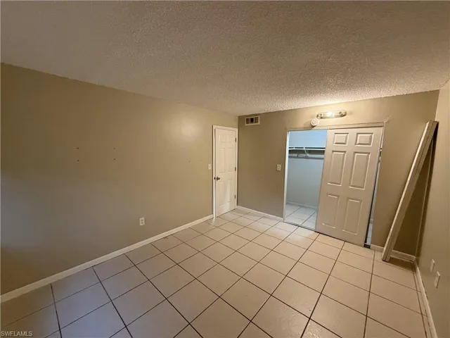 Spare room featuring light tile patterned flooring and a textured ceiling