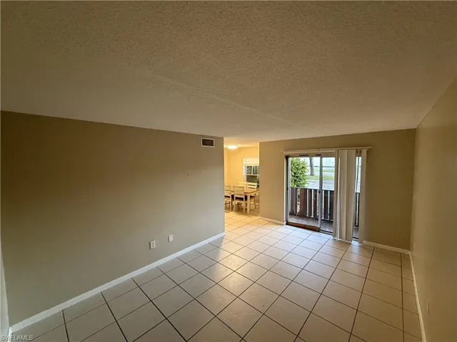 Spare room featuring light tile patterned flooring and a textured ceiling
