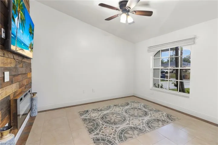 Empty room featuring ceiling fan and light tile floors