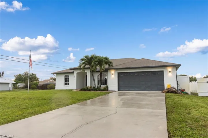 Ranch-style house with a garage and a front lawn