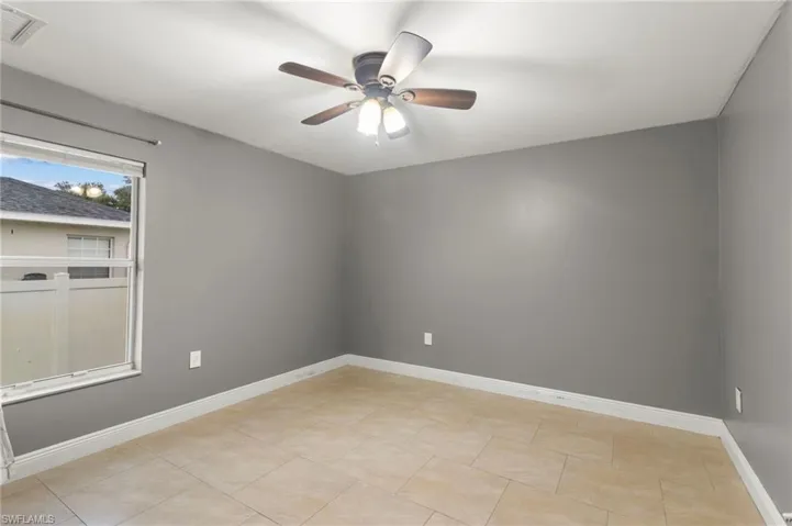 Spare room featuring ceiling fan and light tile floors