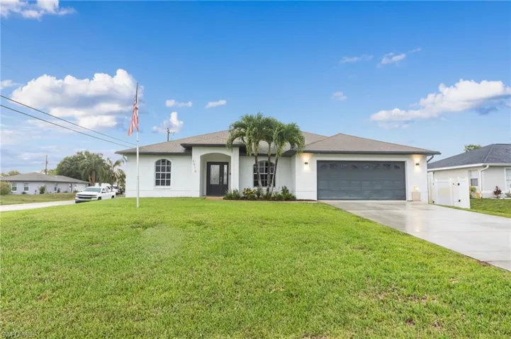 Single story home with a garage and a front yard