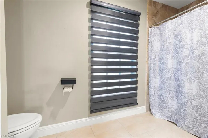 Bathroom featuring tile flooring, toilet, and radiator heating unit