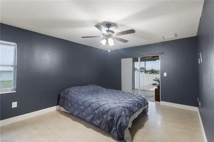 Tiled bedroom featuring ceiling fan