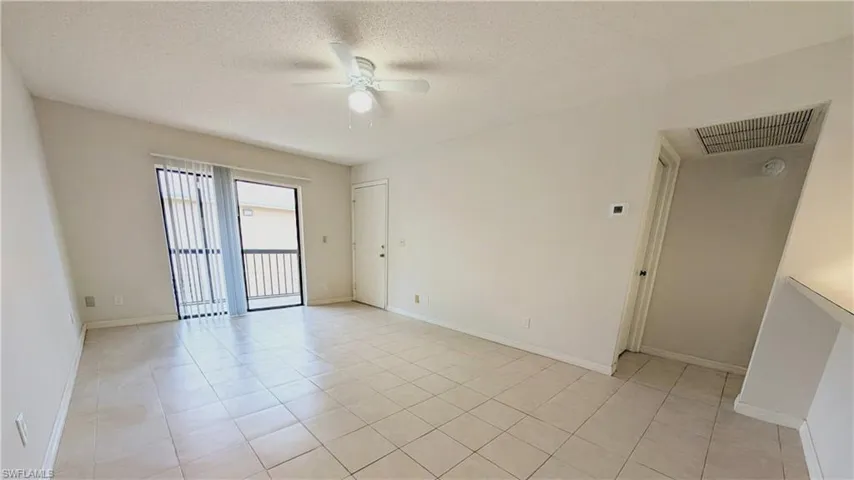 Spare room featuring light tile patterned floors, a textured ceiling, and a ceiling fan