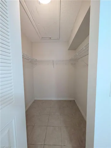 Walk in closet with light tile patterned floors