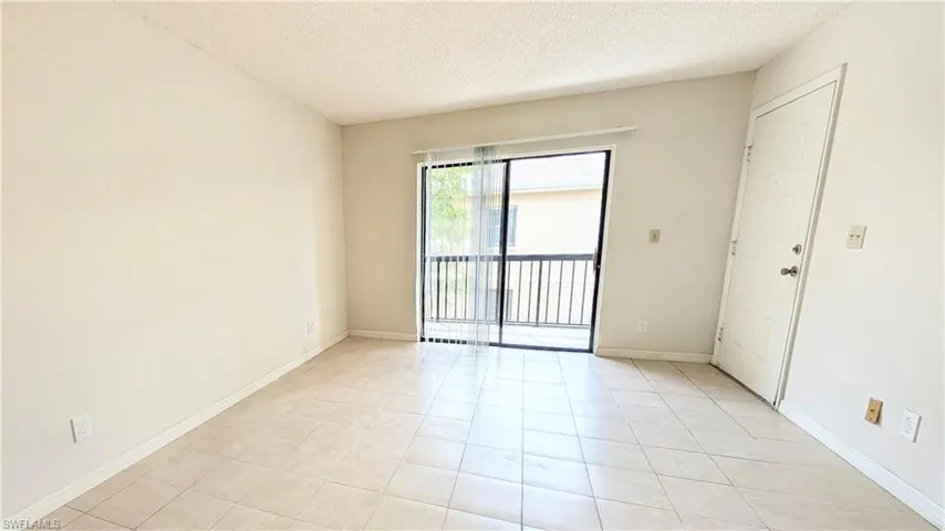 Spare room with a textured ceiling and light tile patterned floors