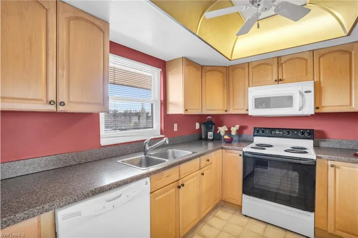 UPDATED WARM WOOD CABINETRY, COORDINATING COUNTERS, AND NEWER IMPACT WINDOW...