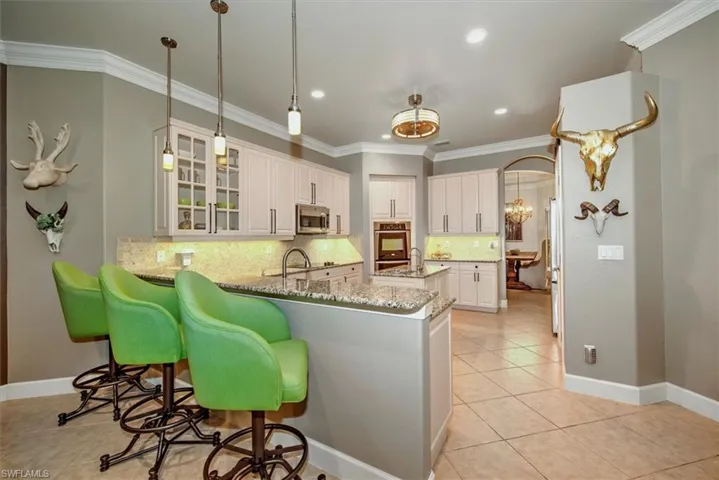 Kitchen featuring stainless steel appliances, upgraded white cabinetry, kitchen peninsula and gorgeous  countertops,