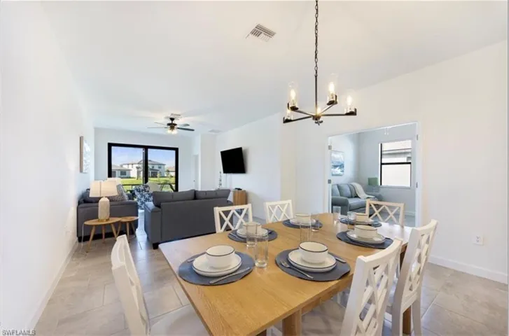Dining space with plenty of natural light, a chandelier, and a ceiling fan
