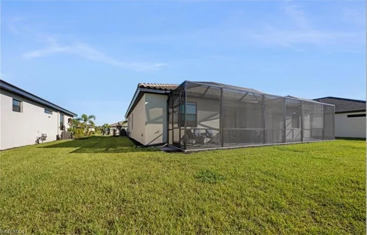 Back of property featuring a yard, a lanai, and a sunroom