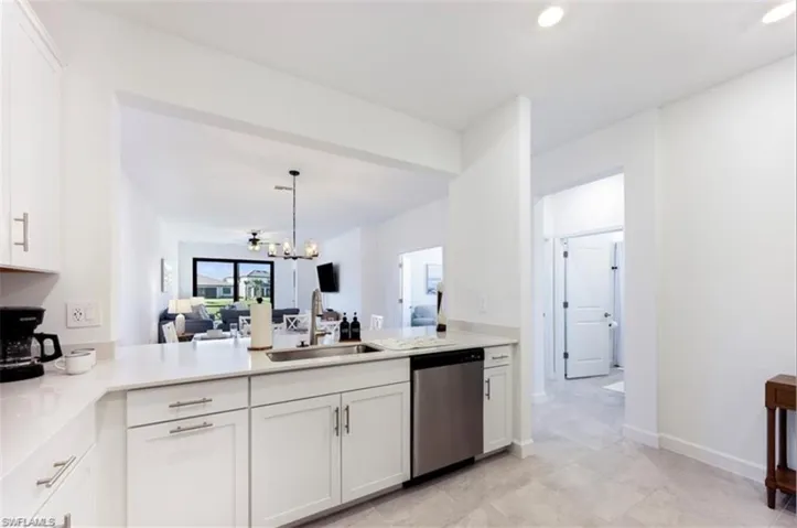 Kitchen with white cabinetry, stainless steel dishwasher, open floor plan, decorative light fixtures, and recessed lighting