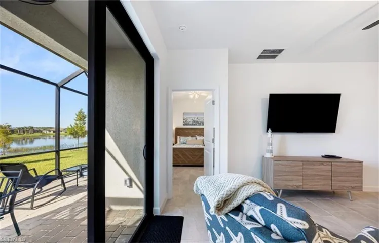Bedroom featuring a water view, a sunroom, and ensuite bathroom