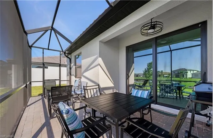Sunroom / solarium with outdoor dining space and a patio