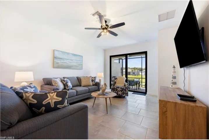 Living area with light tile patterned floors and a ceiling fan
