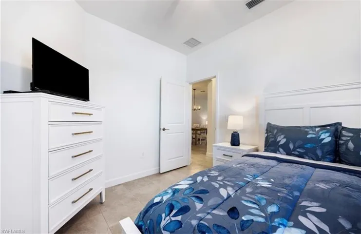 Bedroom with baseboards and light tile patterned floors