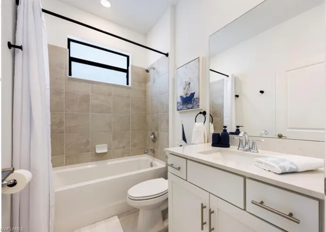 Bathroom with shower / bath combo with shower curtain and vanity
