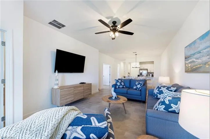 Living room featuring a ceiling fan and a chandelier