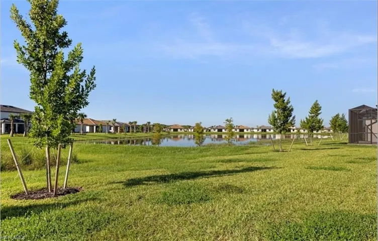 View of grassy yard with a residential view and a water view