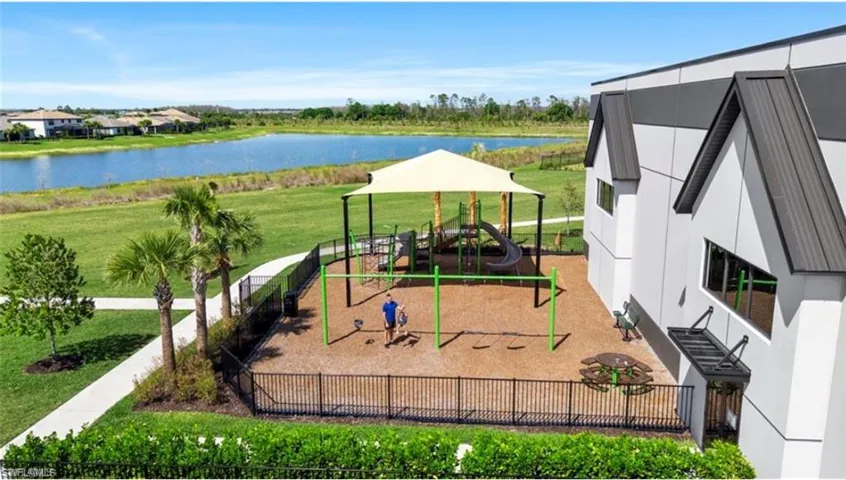 Community play area featuring a water view and a patio area