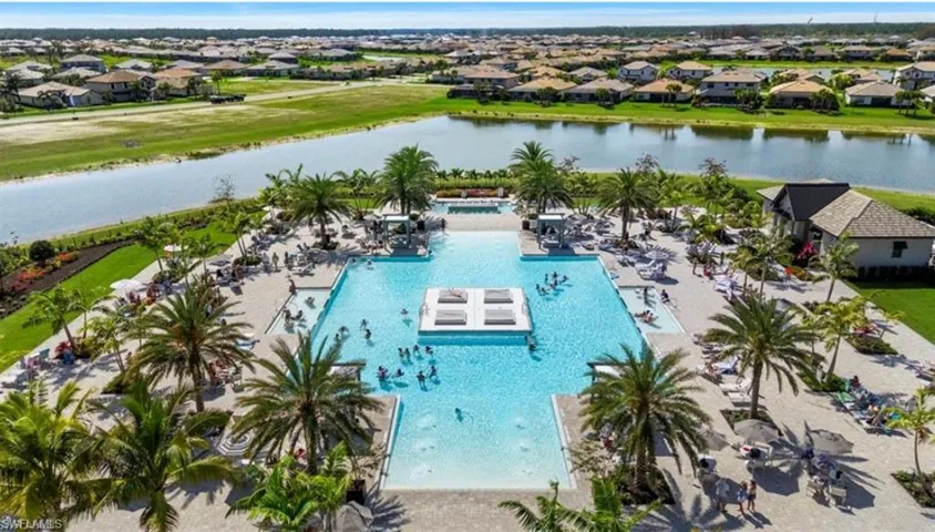 Aerial perspective of suburban area with a nearby body of water and a pool