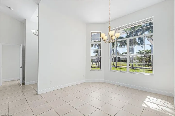 Unfurnished dining area featuring a chandelier and light tile patterned floors