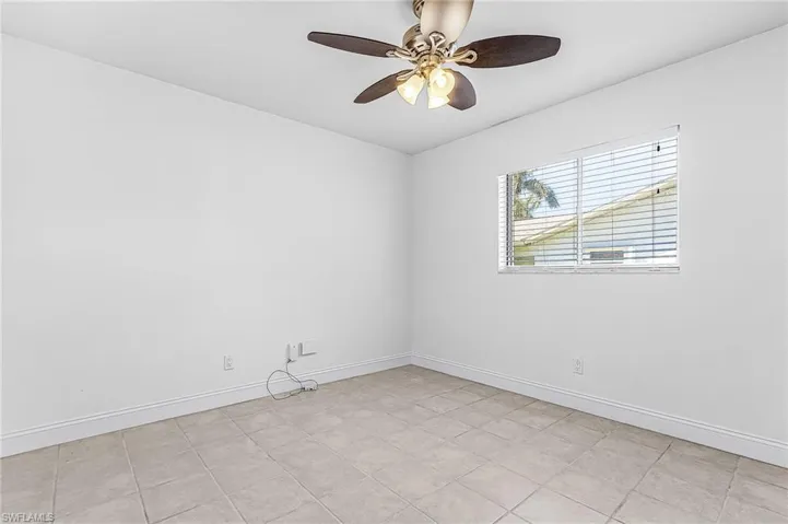 Spare room featuring a ceiling fan and baseboards