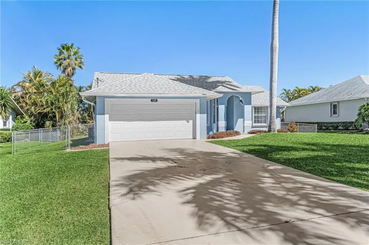 Ranch-style house with an attached garage, driveway, roof with shingles, and stucco siding