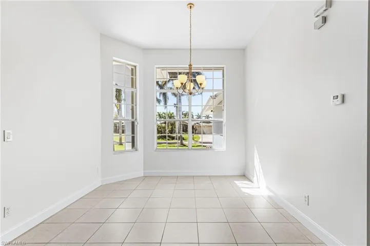 Unfurnished dining area featuring hanging lights and light tile patterned floors