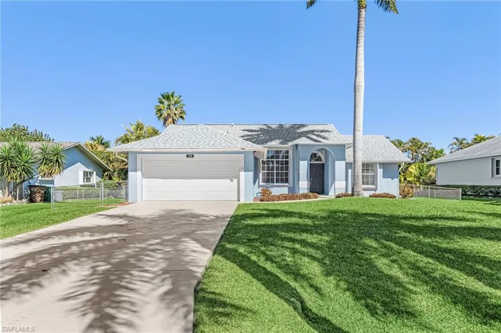 Single story home with an attached garage, driveway, a shingled roof, and stucco siding