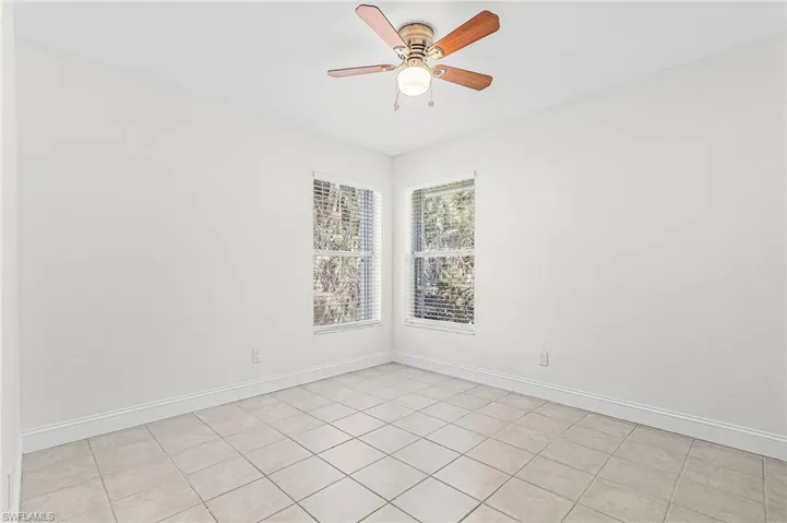 Empty room featuring a ceiling fan and light tile patterned flooring
