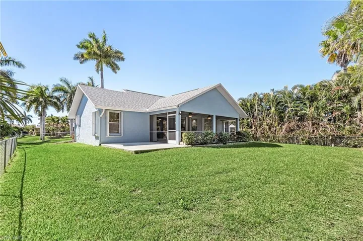 Rear view of house with a fenced backyard, stucco siding, a sunroom, a patio, and a ceiling fan