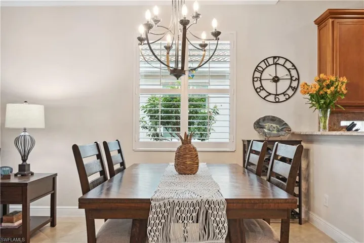 Tiled dining area featuring a notable chandelier