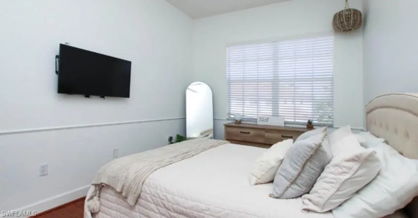 Bedroom with wood finished floors and baseboards
