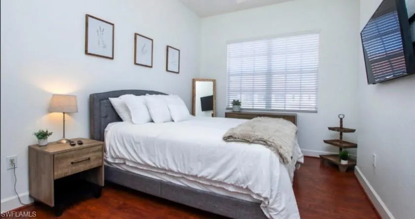 Bedroom featuring dark wood finished floors and baseboards