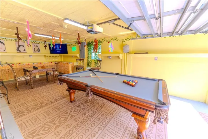Game room with pool table and electric panel- Virtually Edited Image
